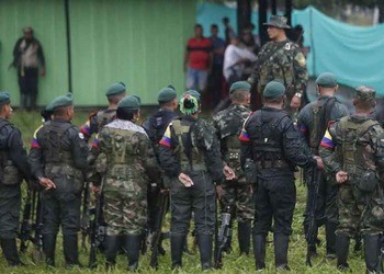 Armed combatants from the General Central Staff of the ex-FARC mafia stand in a group.